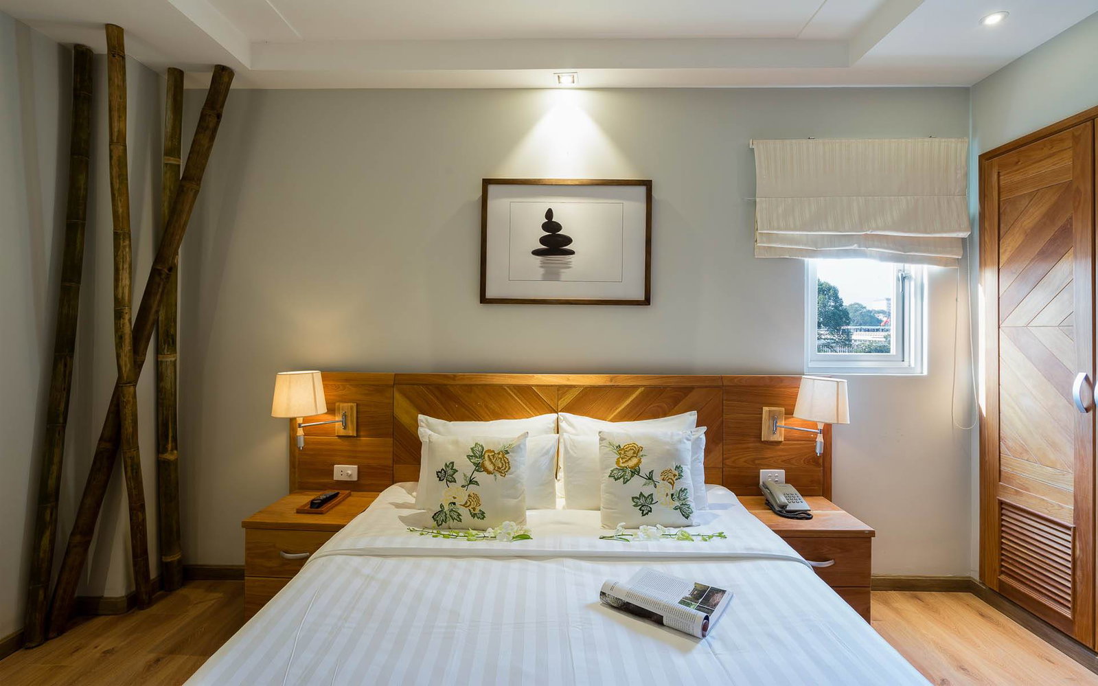 Deluxe room at Silverland Yen boutique hotel in Ho Chi Minh City, with warm wood tones and a bamboo accent