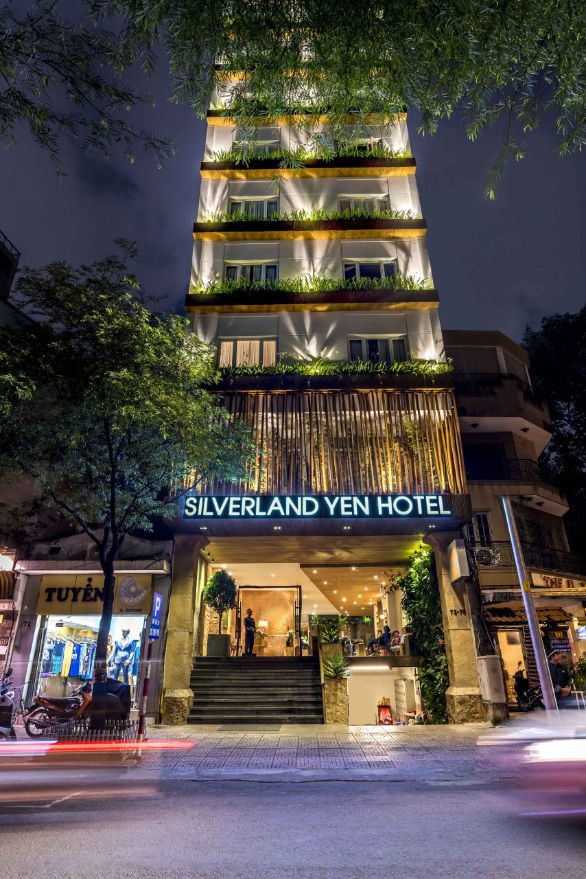 Yen Rooftop Bar: An Award-Winning Rooftop Bar in District 1 6 Silverland Yen Hotel lit at night on Thu Khoa Huan Street in District 1, with planted balconies on every floor