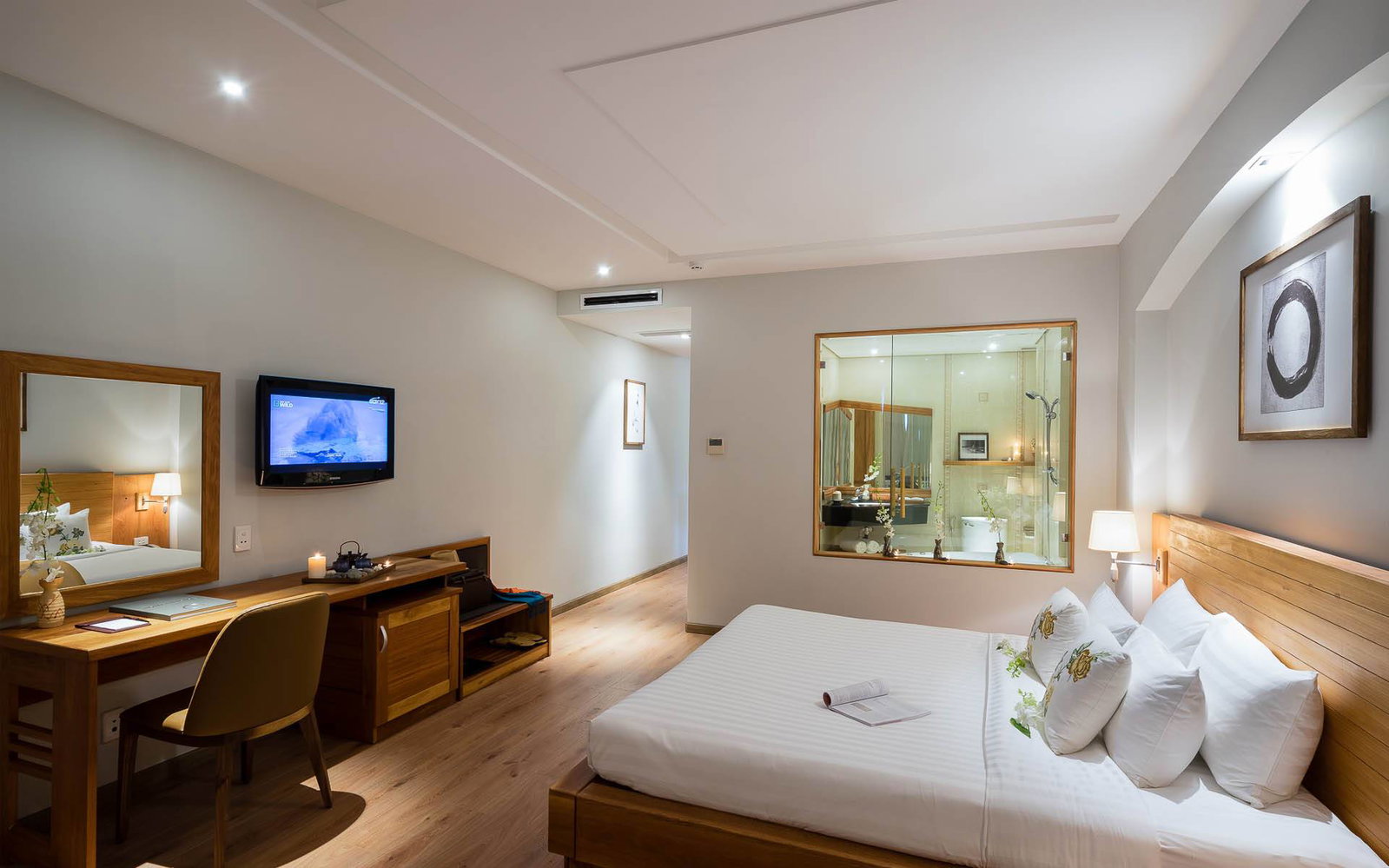 Suite at Silverland Yen showing the bedroom and the glass-walled bathroom with a Jacuzzi tub