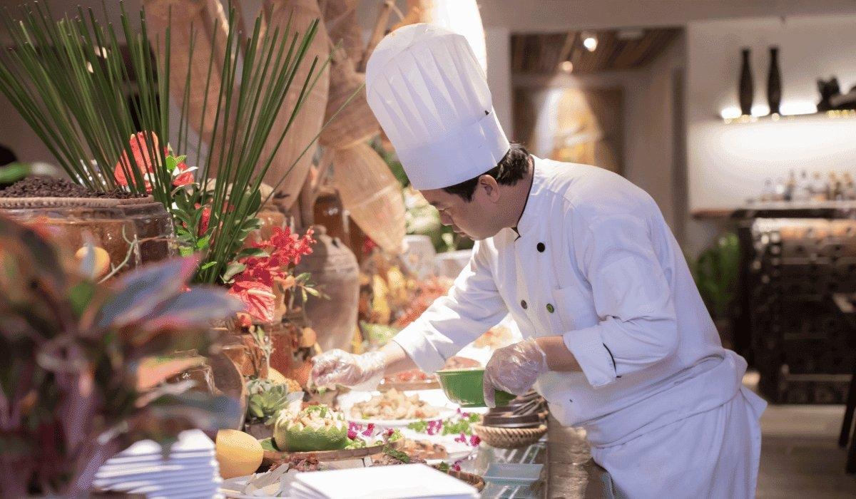 A chef finishing a plate at The Nest buffet counter