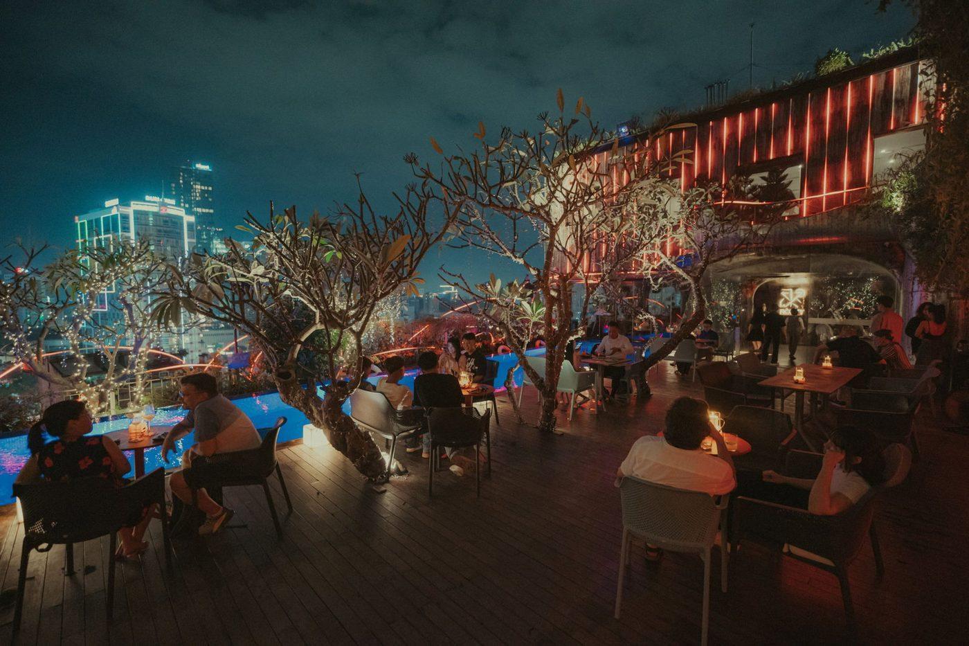 Poolside seating at Rooty Bar overlooking the Ho Chi Minh City skyline