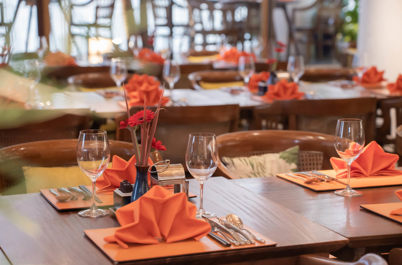 The Nest Restaurant dining table with orange napkin settings at The Myst Dong Khoi