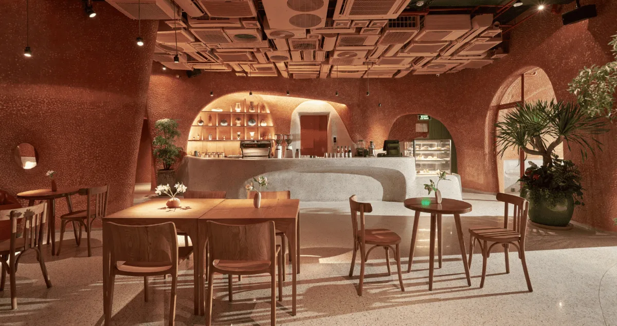 Best Coffee Shops for a Business Meeting in District 1 1 The interior of Bason Café Ben Thanh, a coffee shop for a business meeting in District 1, with terracotta walls and a curved terrazzo counter