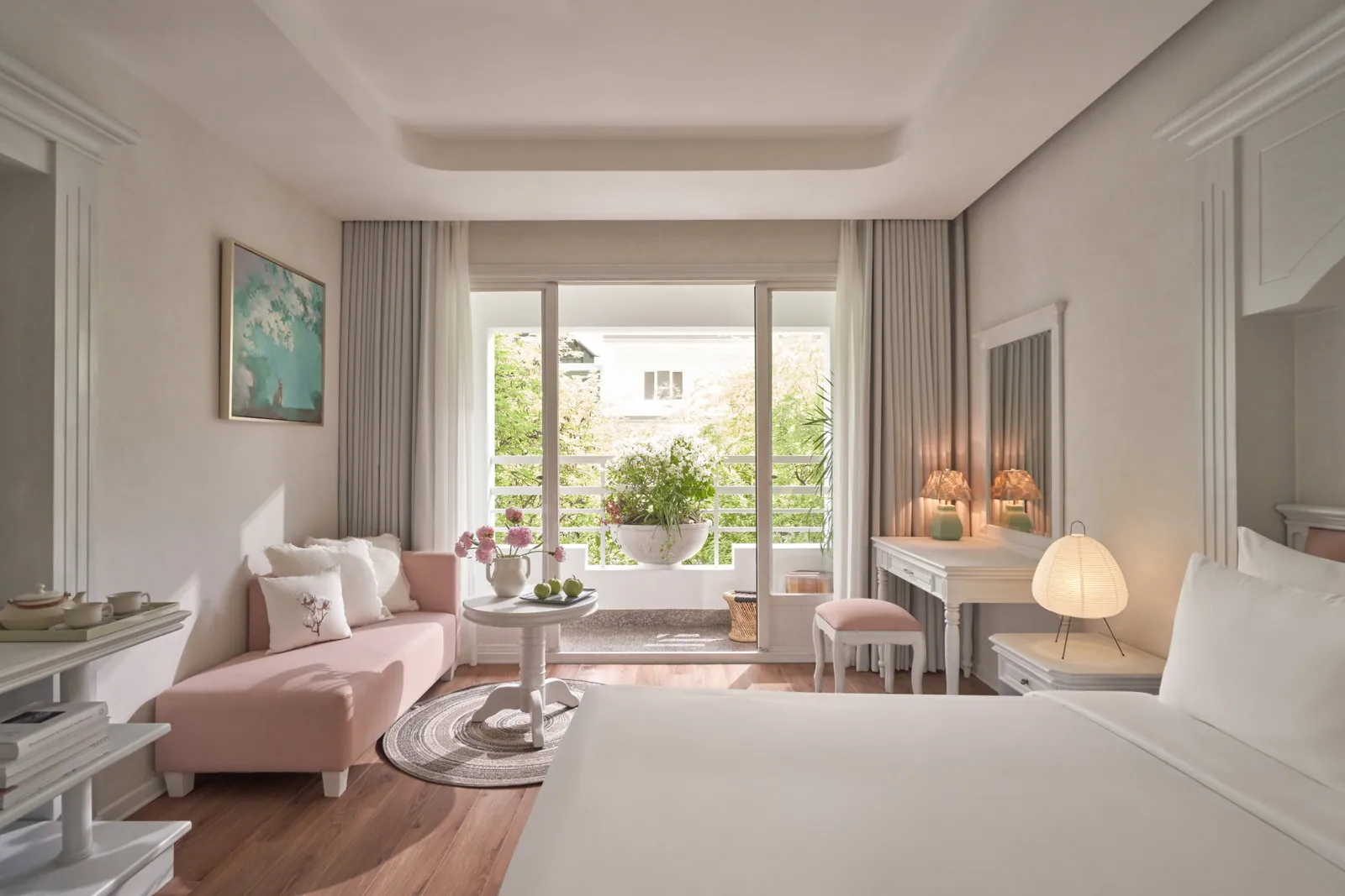 Bougainvillaea Signature room at Silverland Mây, seating area and bed facing the private balcony with bougainvillea vines