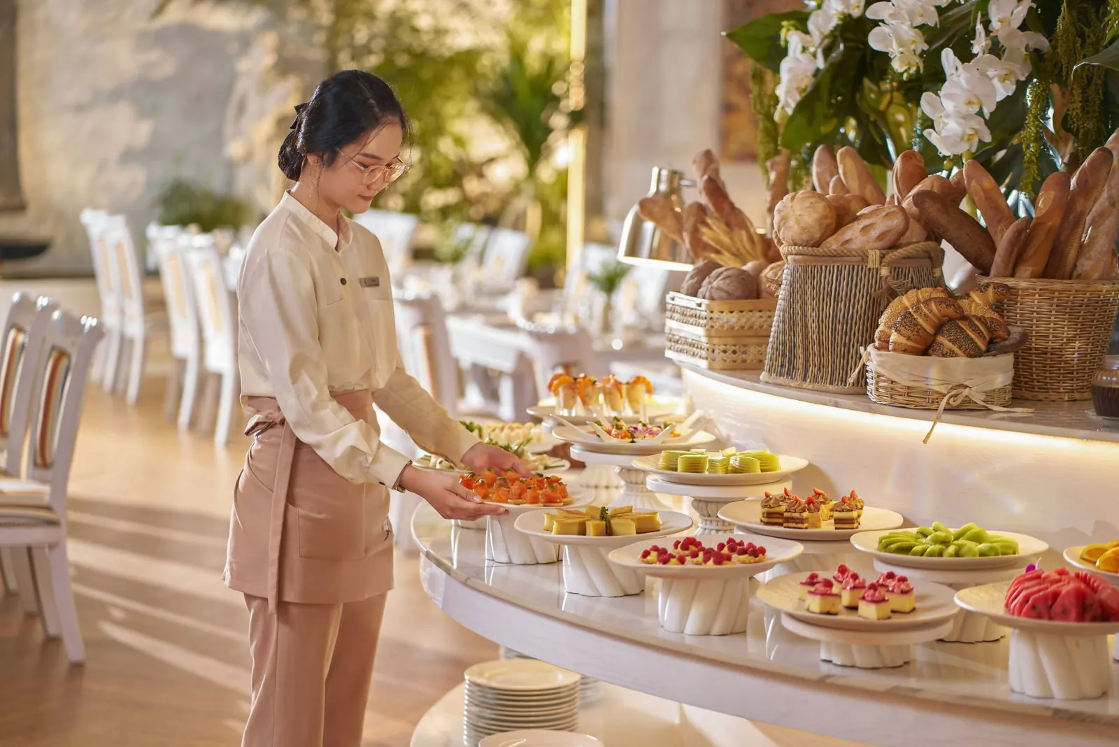 Gòn Restaurant staff at Silverland Mây preparing the afternoon tea buffet with pastries and fresh bread