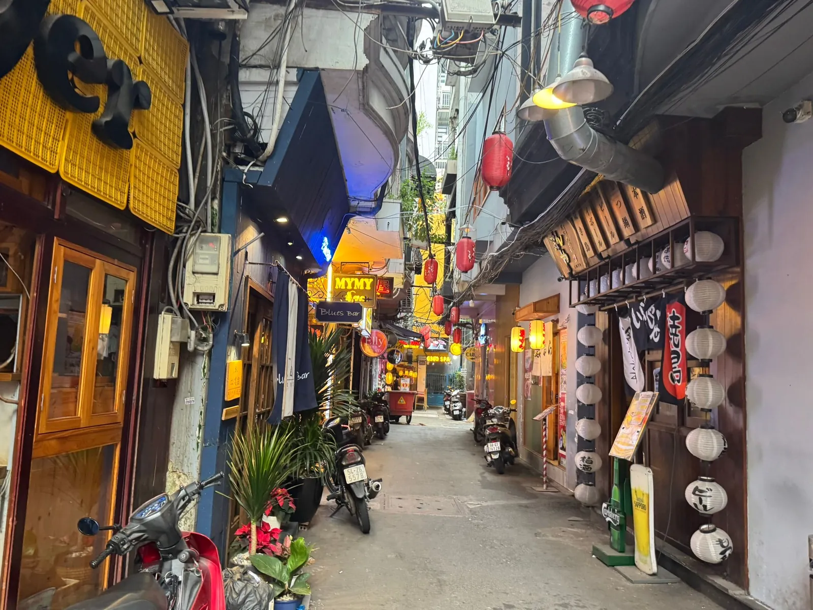 Narrow alley in Saigon's Japan Town strung with red lanterns and Japanese izakaya signage