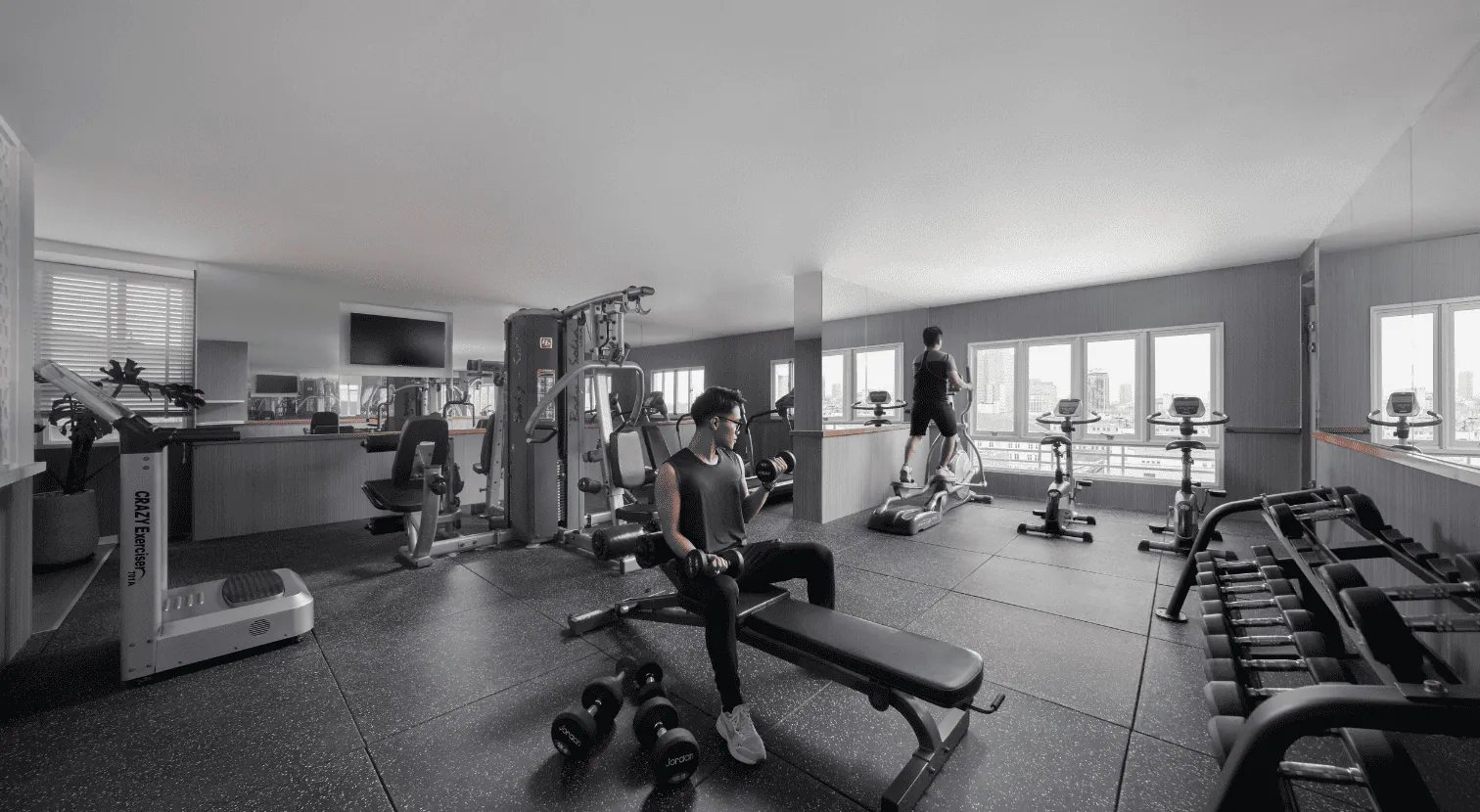 Fitness center at Silverland Mây with city-view windows, free weights and cardio machines